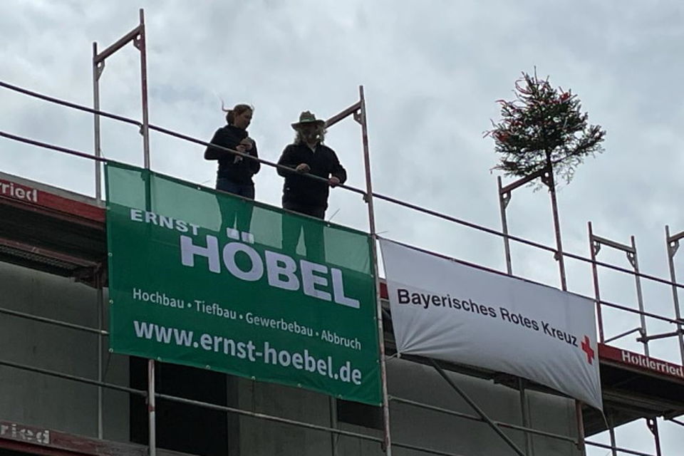 Hebaufspruch auf dem Gerüst neben geschmückten Bäumchen
