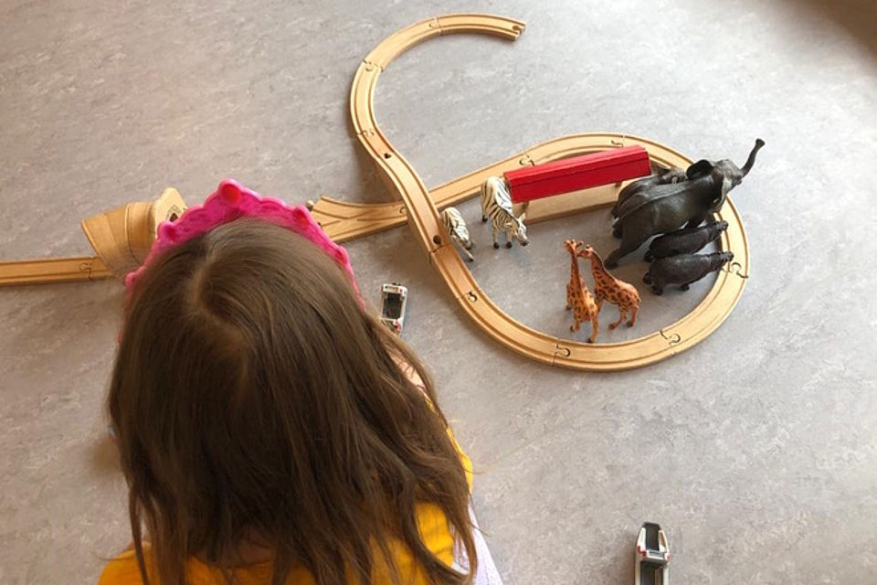 Fantasiespielen mit Tieren und Holzeisenbahn