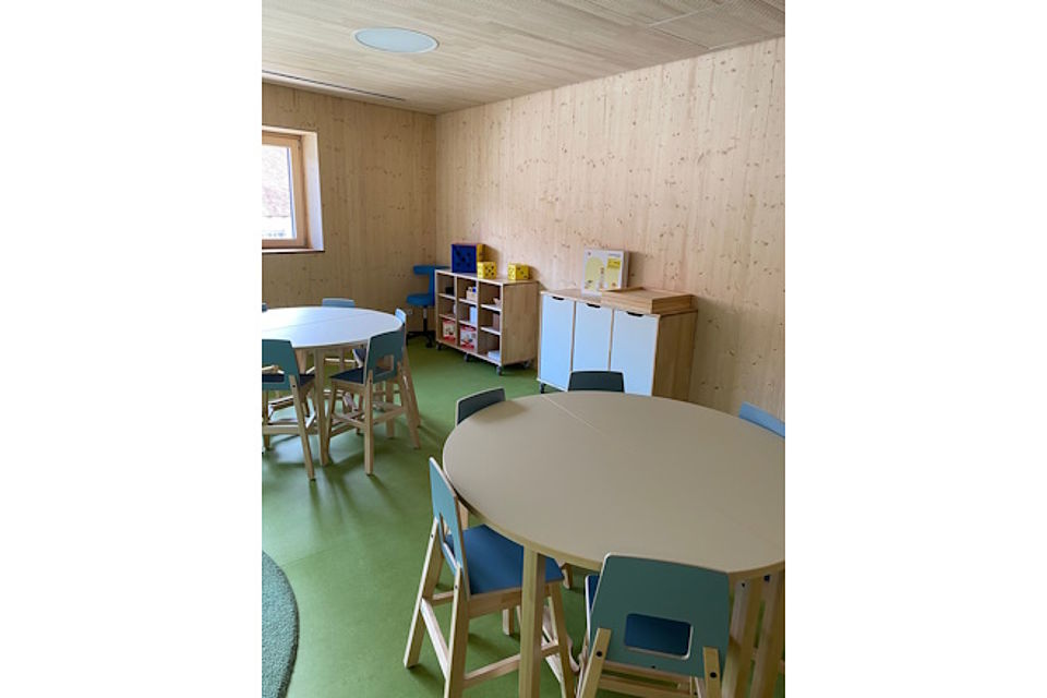 Gruppenraum mit runden Tischen und Stühlen